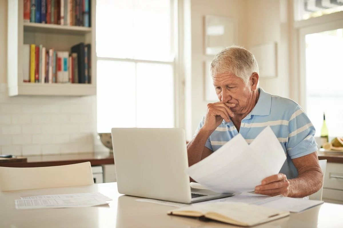 stressed person with papers and laptop 7UsCv1.width 1200 - Mortgage Renewal Switch