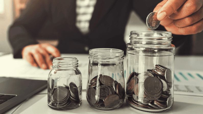 A man putting some coins in a jar