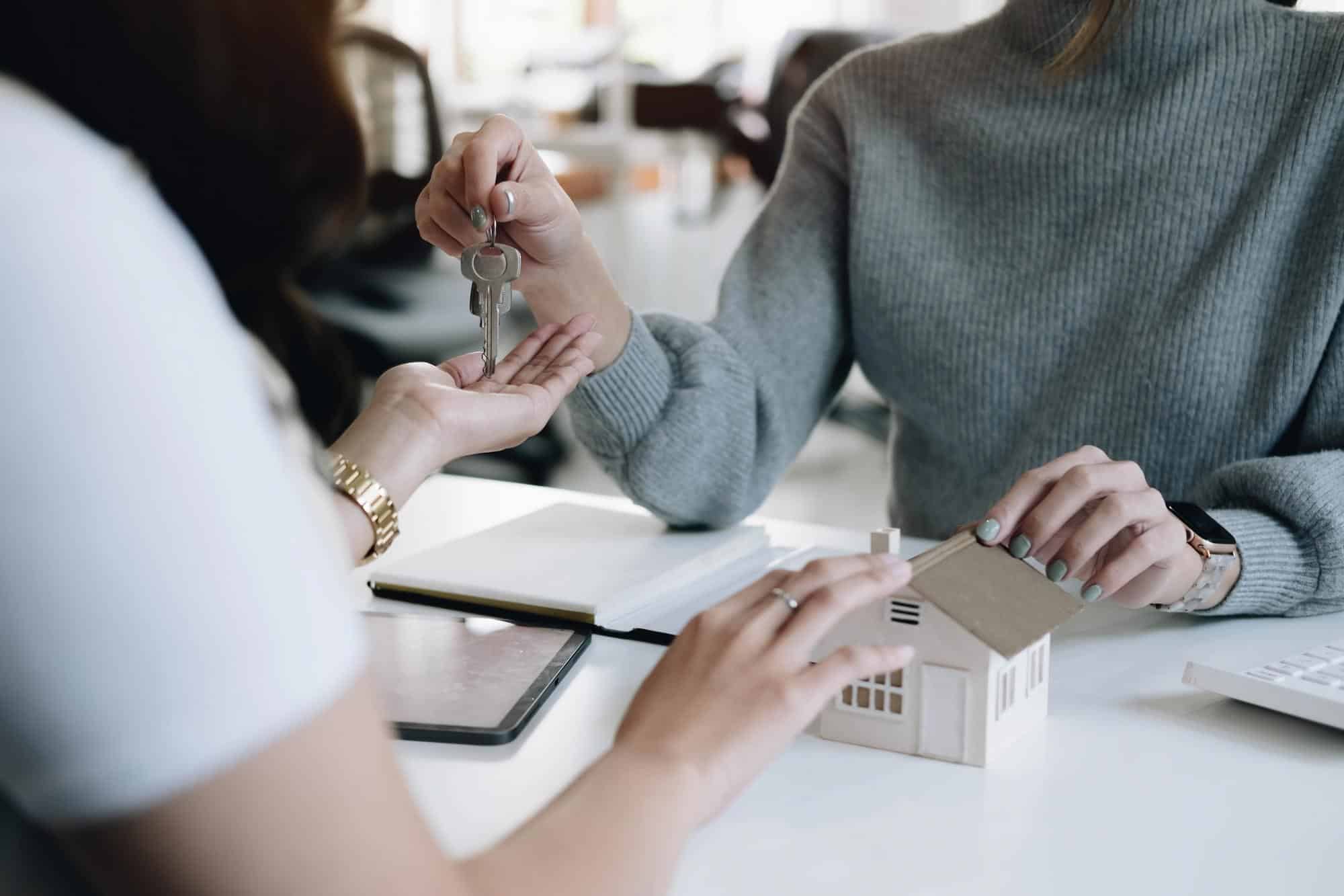 estate agent giving house keys woman sign agreement office - Private Mortgage Lenders - Canada's Biggest Resource