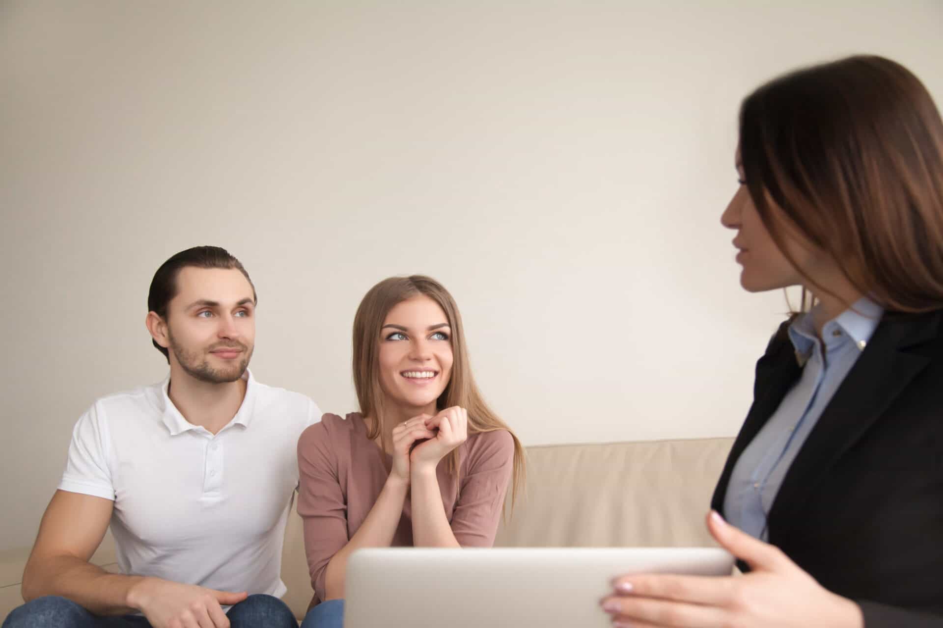 female-manager-realtor-talking-young-happy-couple-indoors heloc vs home equity loan