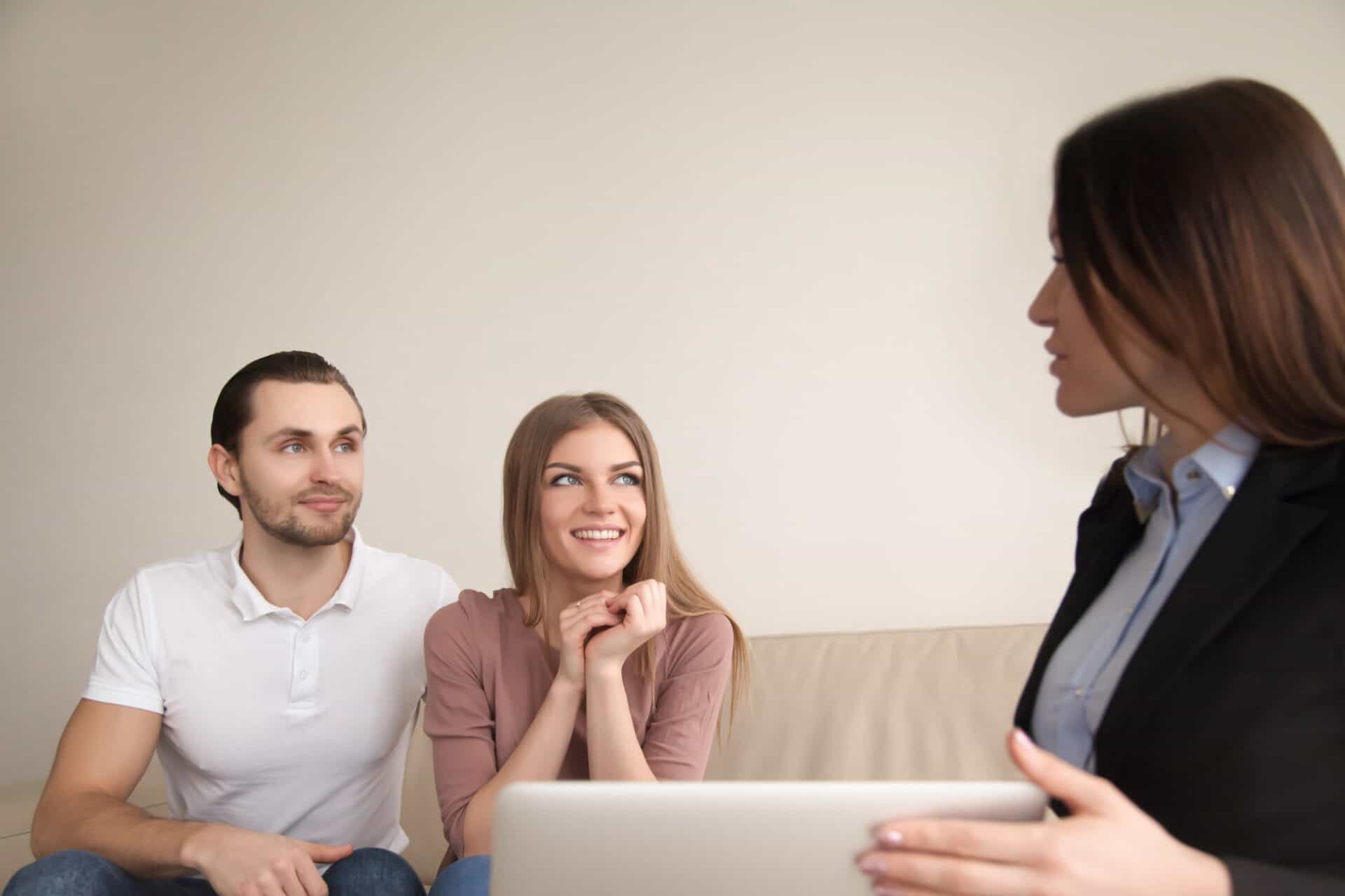 female manager realtor talking young happy couple indoors - How Soon After A Consumer Proposal or Bankruptcy Can I Get A Mortgage?