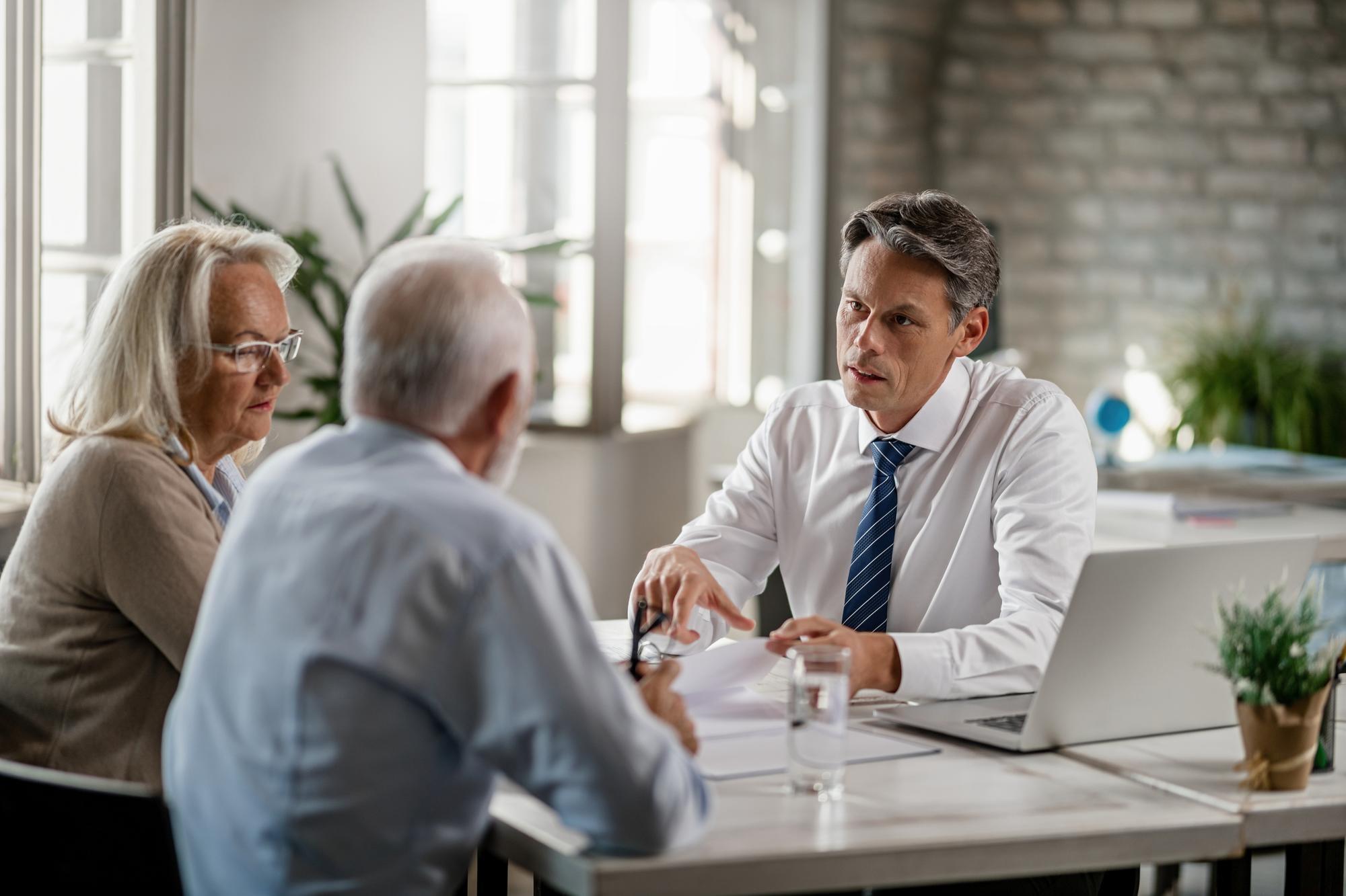 mid adult insurance agent with mature couple analyzing financial reports communicating during meeting office - Secured Line of Credit (HELOC)