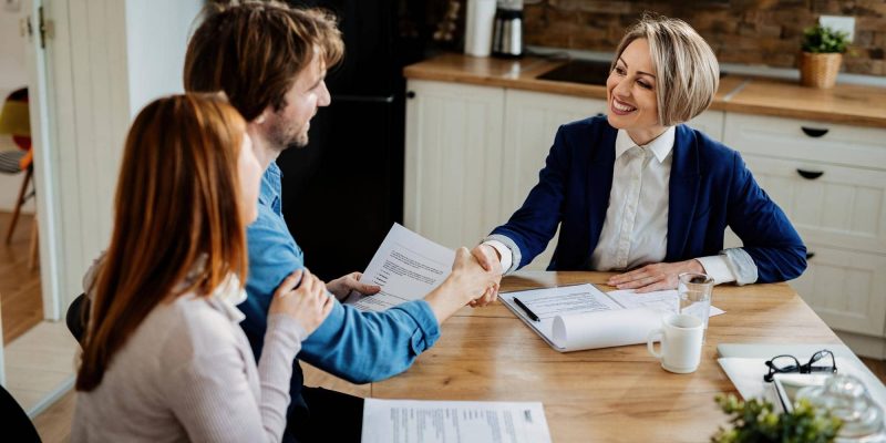 happy-insurance-agent-shaking-hands-with-young-couple-after-successful-meeting.jpg